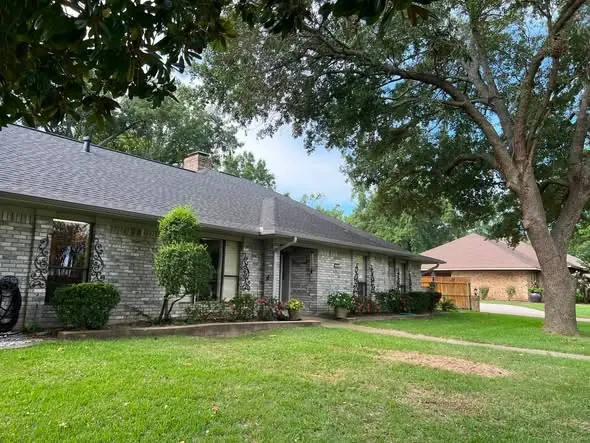 Brick ranch home with a freshly trimmed live oak shading a clean green lawn in Tampa, FL